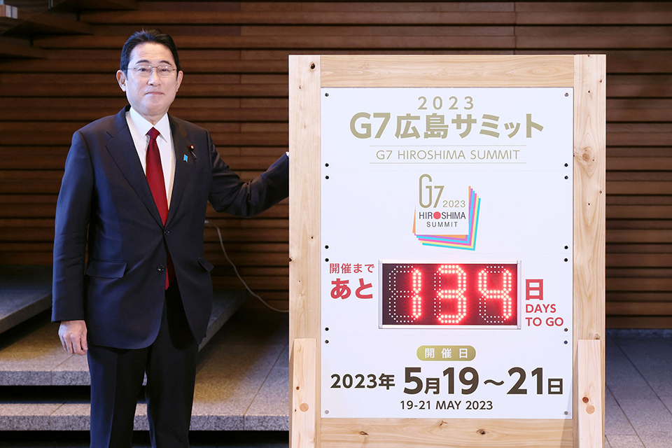 Prime Minister Kishida standing next to the countdown-board for the G7 Hiroshima Summit.