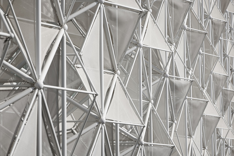 Close-up of complex, geometric structure with interconnected rods and white panels.