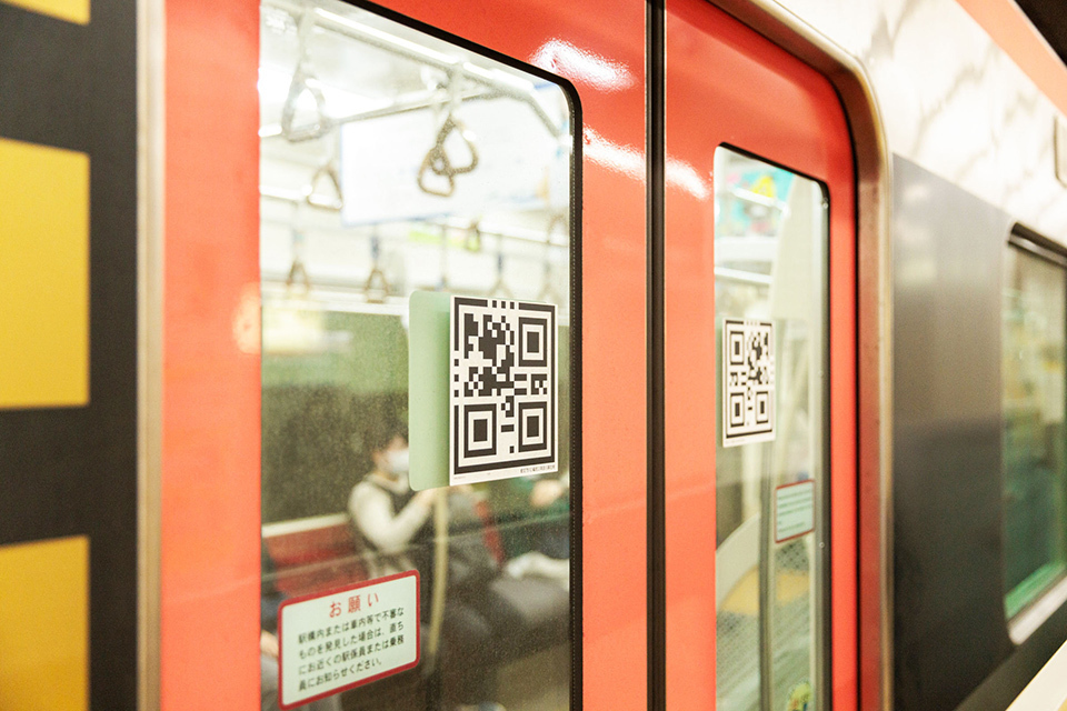 Two closed doors of Toei Subway cars with 2D codes on them.