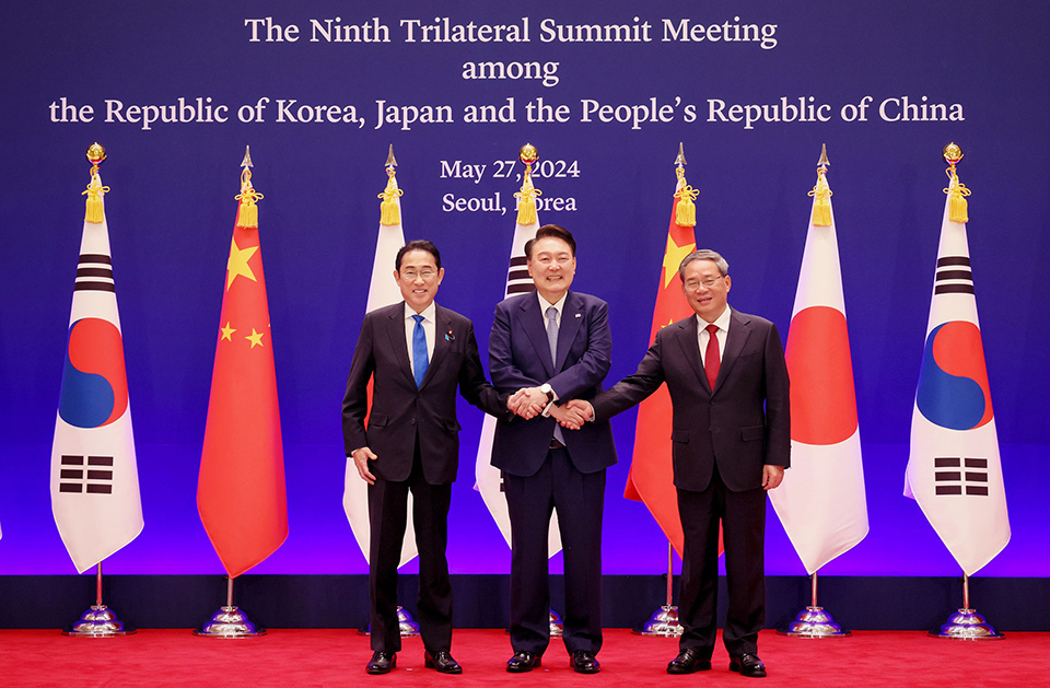 Leaders from South Korea, Japan, and China shaking hands at the Ninth Trilateral Summit Meeting