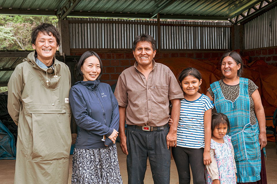 A group of six individuals standing side by side under a shelter.