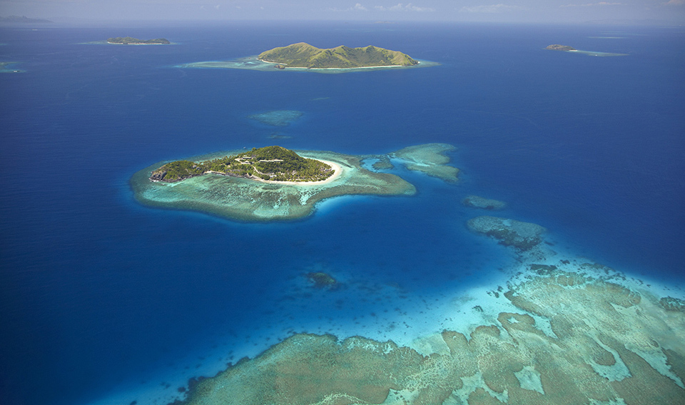 Aerial view of a tropical archipelago and lush green islands in the Pacific region.