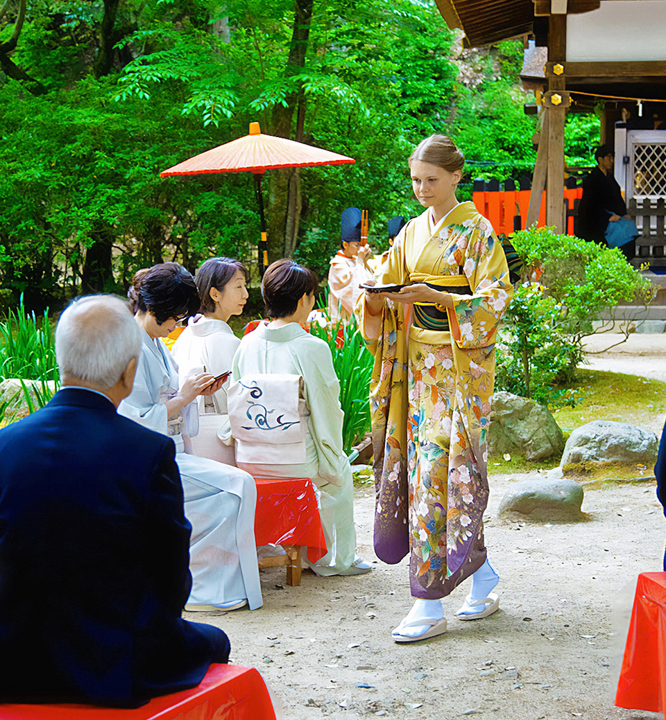 A woman wearing kimono serving sencha green tea to guests at a tea ceremony 