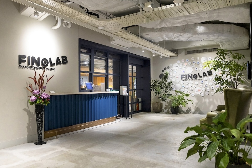 Entrance to the coworking space, decorated with flowers, plants, and the community logo