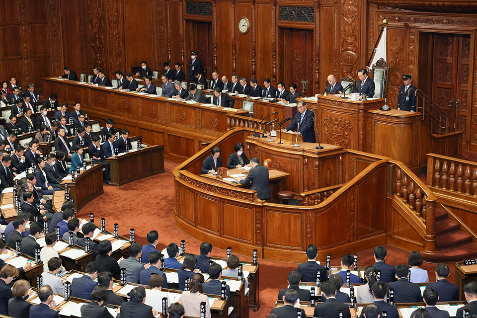 A crowded parliament filled with attendees in suits during Prime Minister's policy speech at the Diet session.