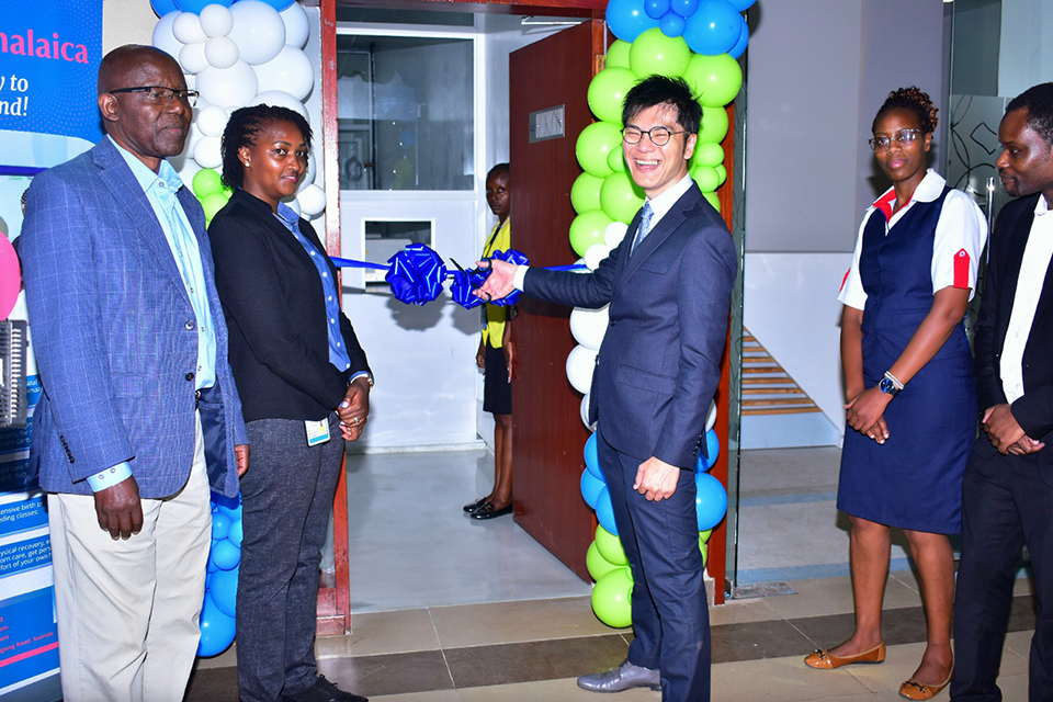 A festive gathering of people around a blue and green balloon marks the opening of a new testing lab in Kenya.