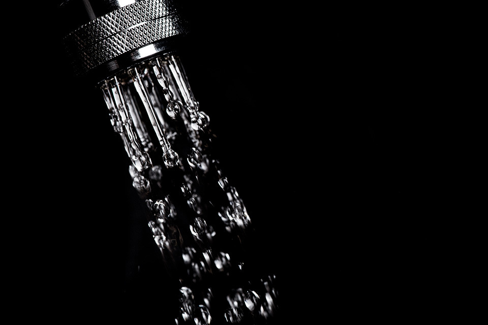 Close-up of a water-saving shower head with water flowing.