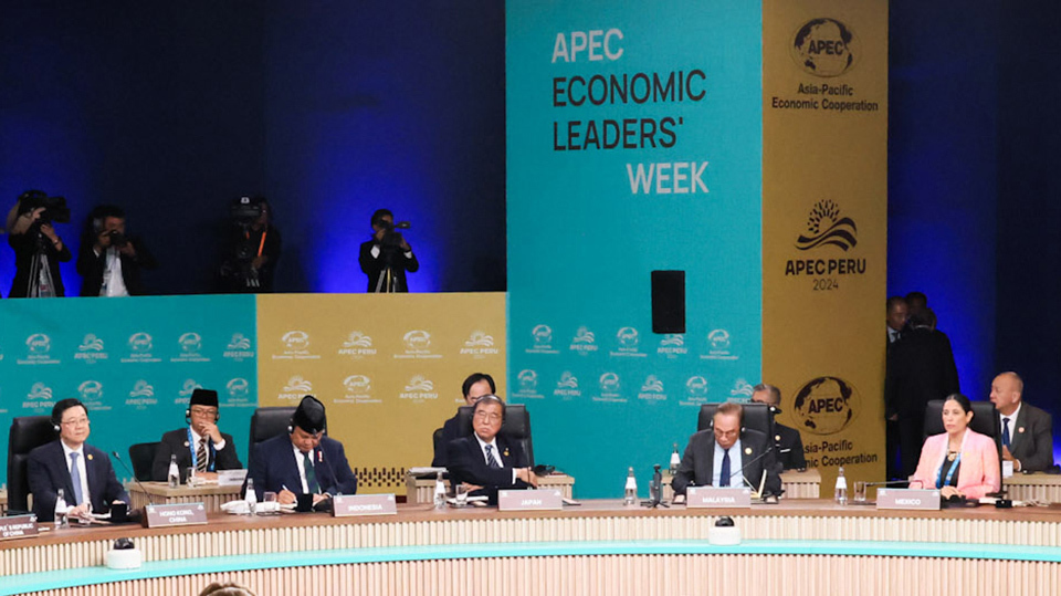 Several men and one woman sitting at a table. They are discussing and pondering.