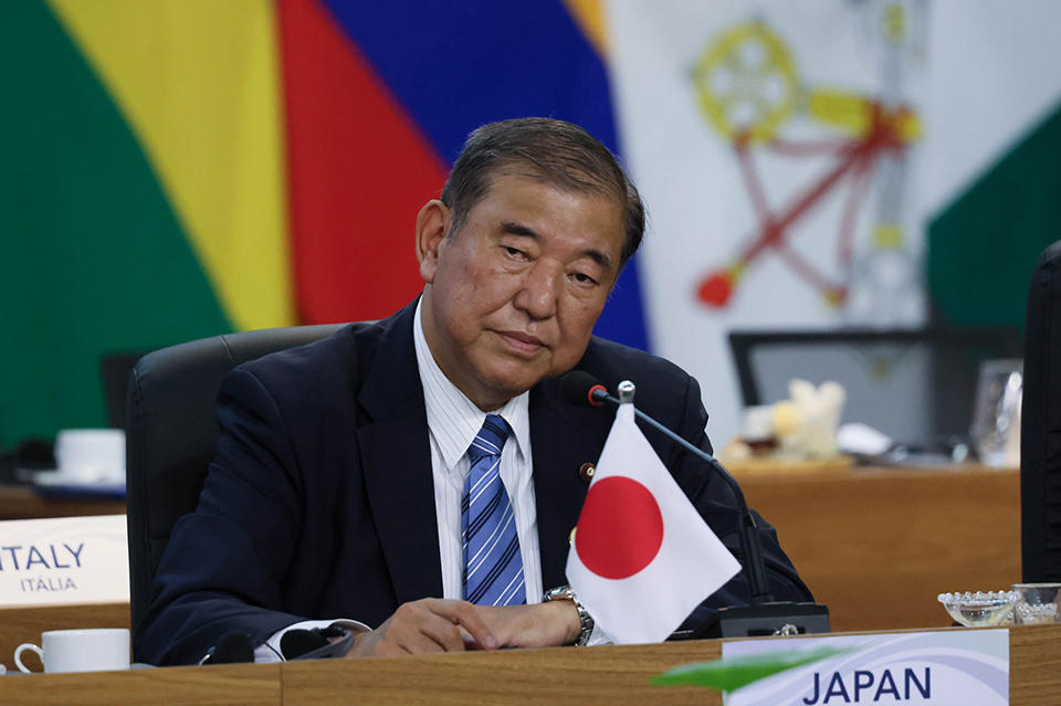 A man participating in a discussion with a serious expression on his face.