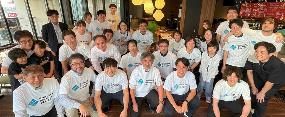 A group of people in white shirts smiling and posing together for a photograph.