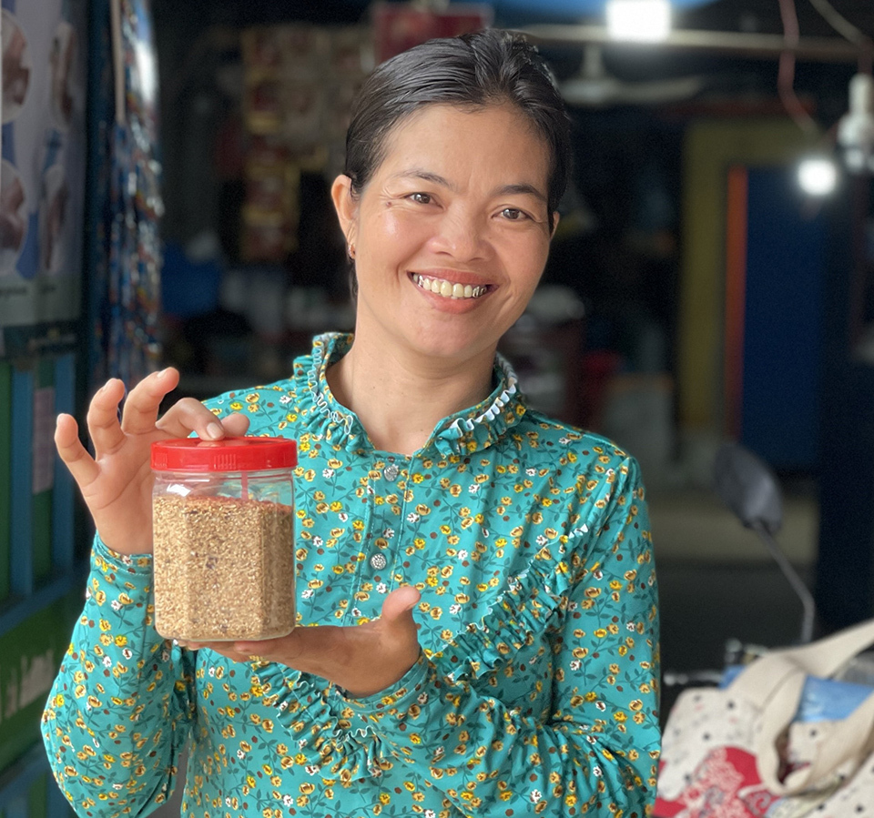 A woman holding a bottle of fish powder.