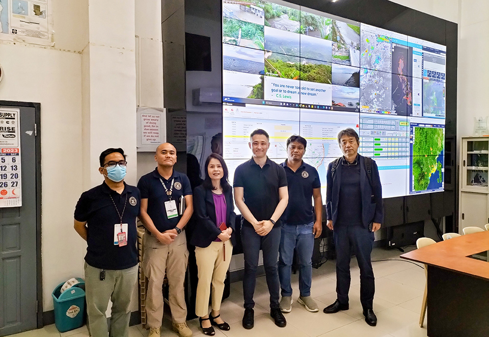 A Group of individuals in front of a wall-to-wall screen at Davao City’s Disaster Risk Reduction and Management Office in the Philippines.